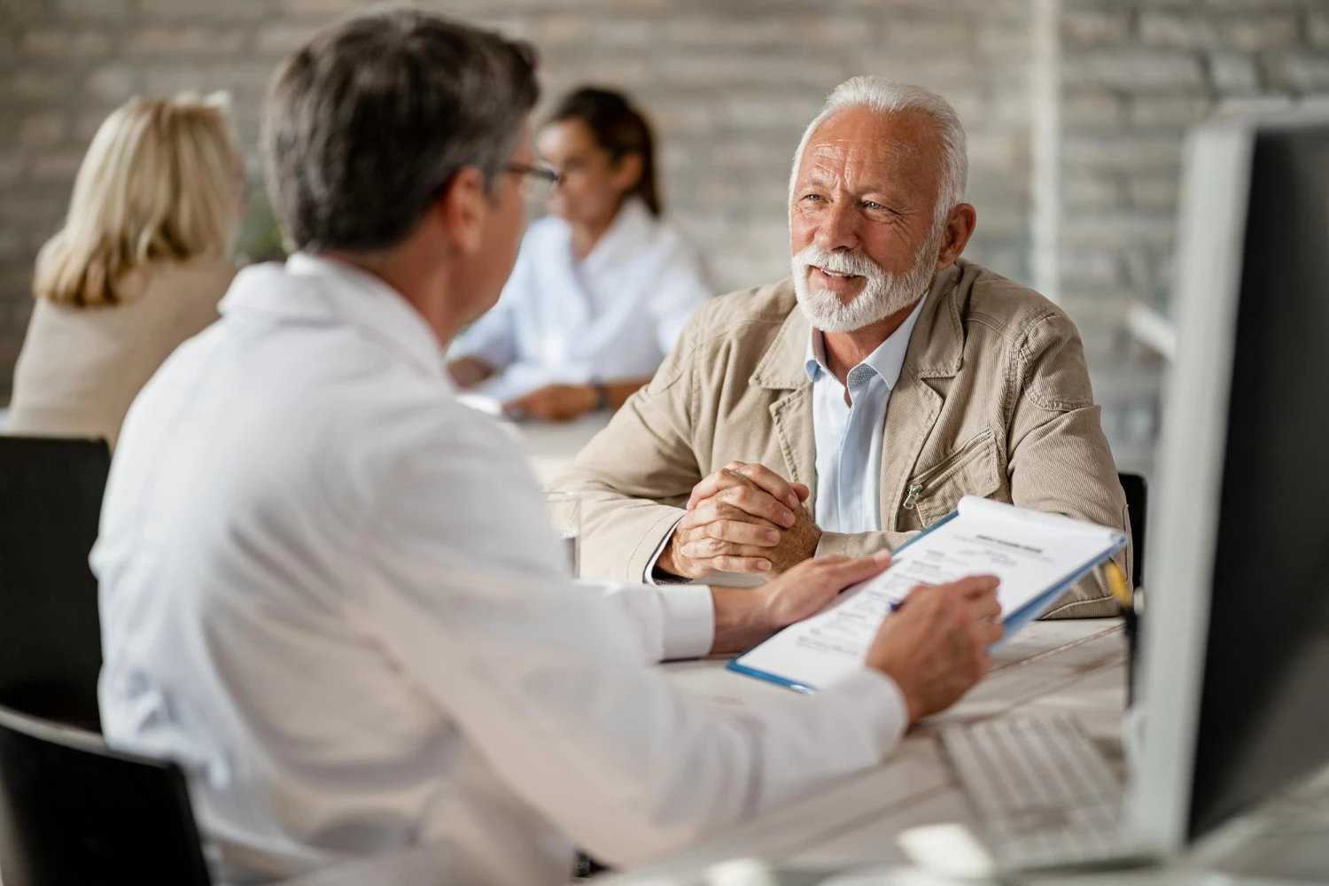 Starejši voznik med zdravniškim pregledom pri specialistu medicine dela, prometa in športa.